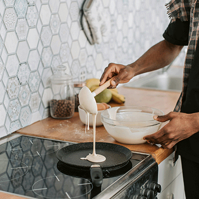 Picture of pancake batter being poured onto frying pan.